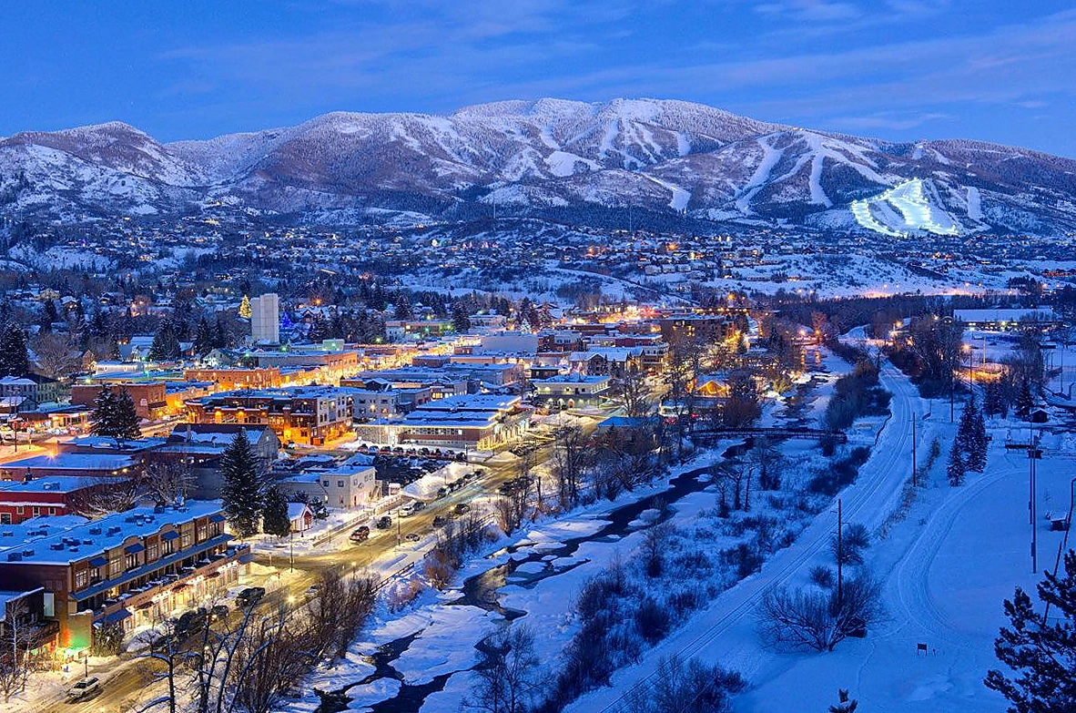 Downtown Steamboat Springs, the Yampa River and the snow-covered ski mountain at winter dusk